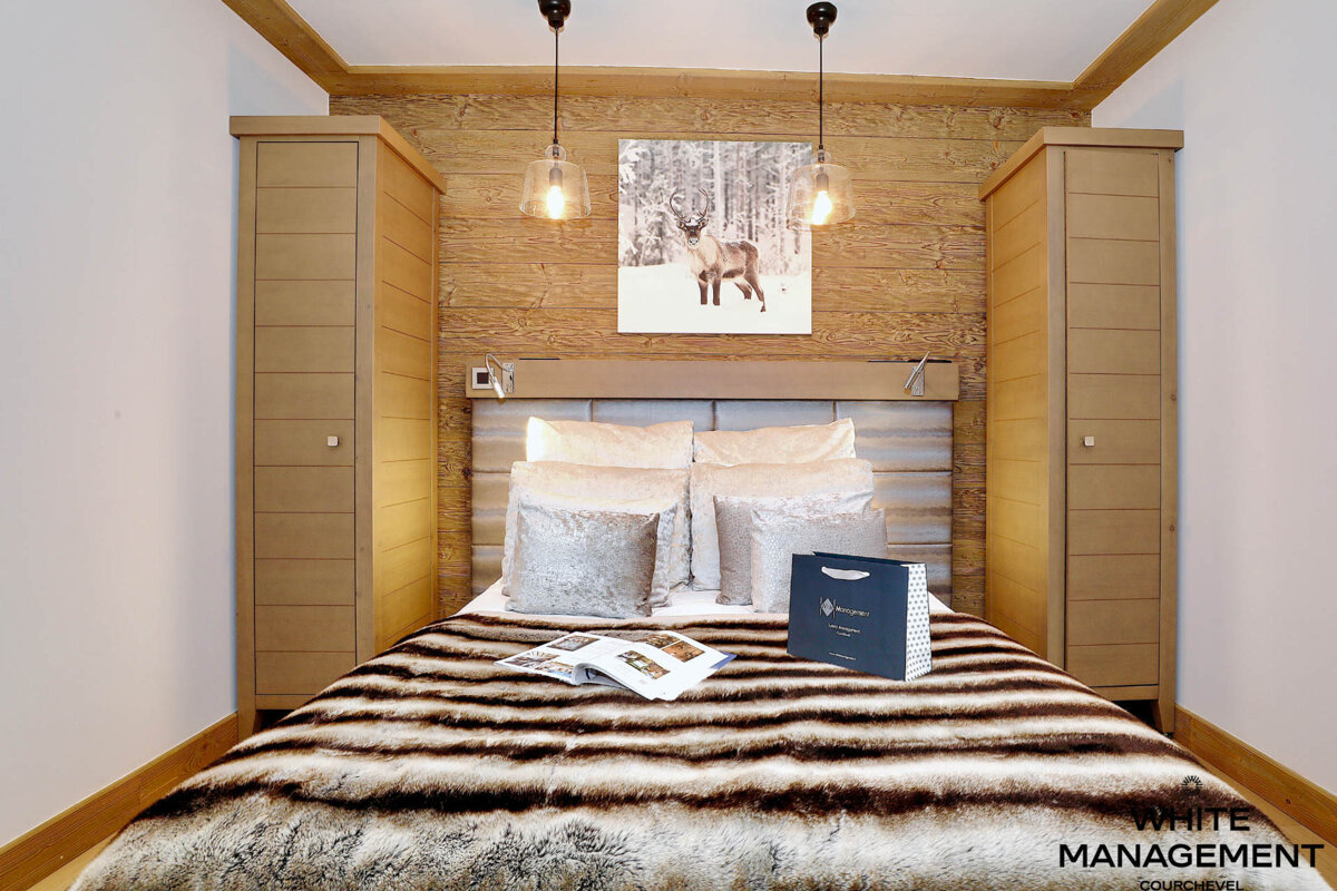 A bedroom with a fur blanket and a picture of a horse on the wall