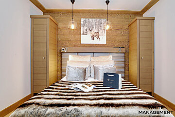 A bedroom with a fur blanket and a picture of a horse on the wall
