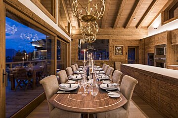 A dining room with a long wooden table and chairs