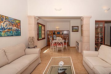 A living room with a table and chairs and a painting on the wall