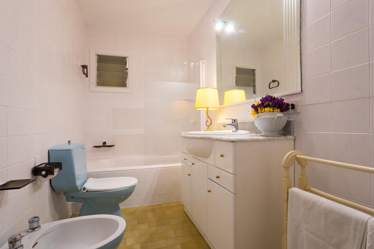 A bathroom with a blue toilet and a white sink