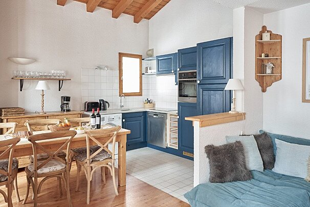 A kitchen with blue cabinets and stainless steel appliances