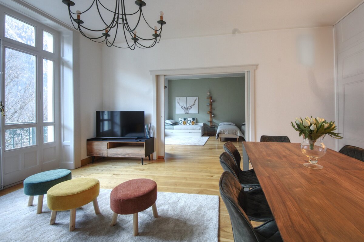 A living room with a table and chairs and a television