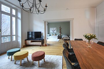 A living room with a table and chairs and a television
