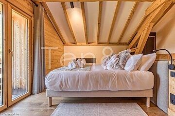 A bed with white sheets and pillows in a room with a sign that says ten8 holidays