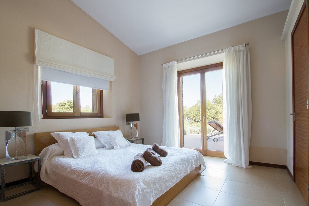 A bedroom with a large bed and a sliding glass door