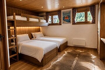 Cozy wooden cabin bedroom with two twin beds, an overhead bunk, a cowhide rug, and warm lighting.