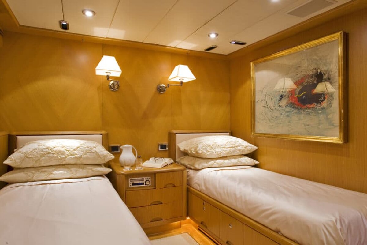 A bedroom with two beds and a painting on the wall