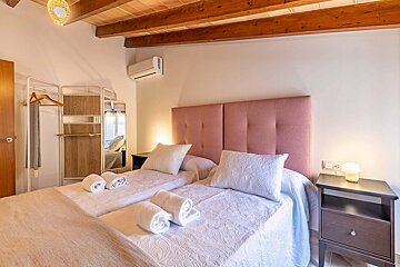 A bedroom with a pink headboard and two beds