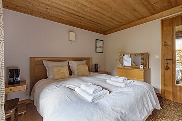 A bedroom with a large bed and a mirror