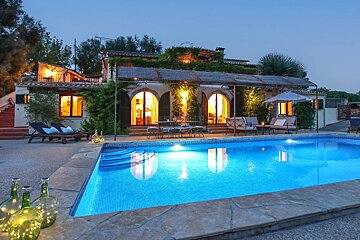 A large house with a swimming pool in front of it