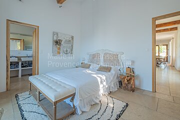 A bedroom with a bed and a painting on the wall that says made in provence