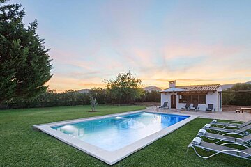 A large swimming pool with a house in the background