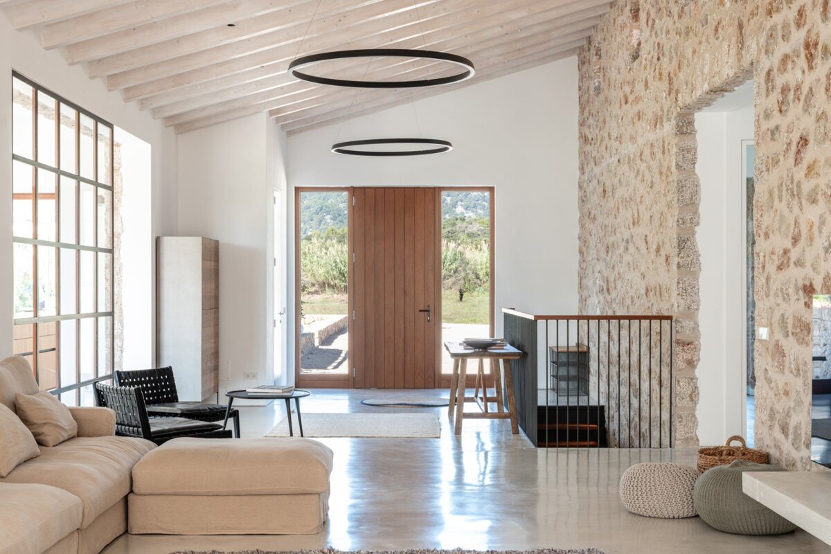 A living room with a couch and chairs and a wooden door
