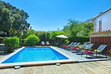 A large swimming pool surrounded by chairs and umbrellas