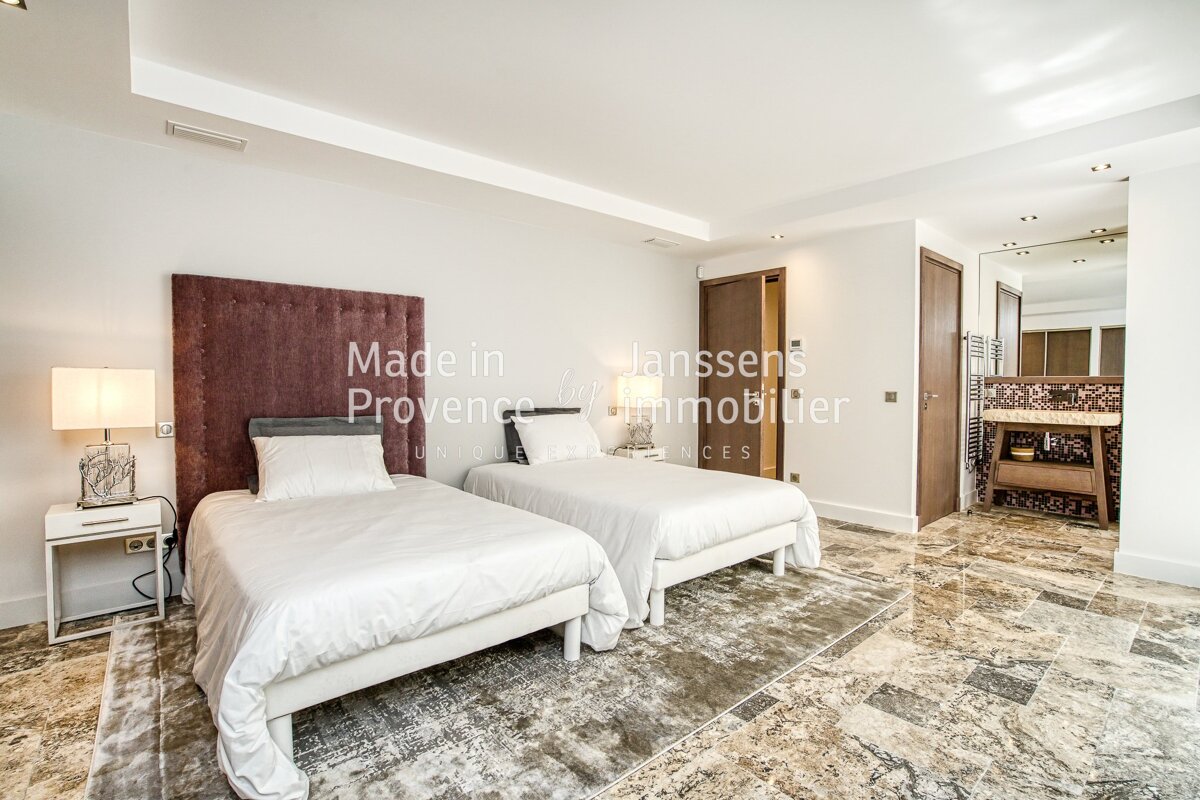 A bedroom with two beds and the words made in provence on the wall