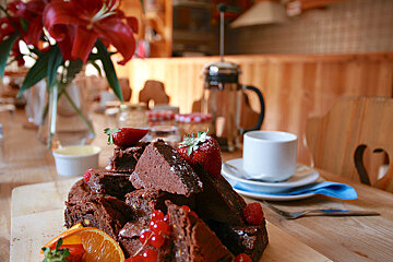 A stack of brownies with strawberries and raspberries on top
