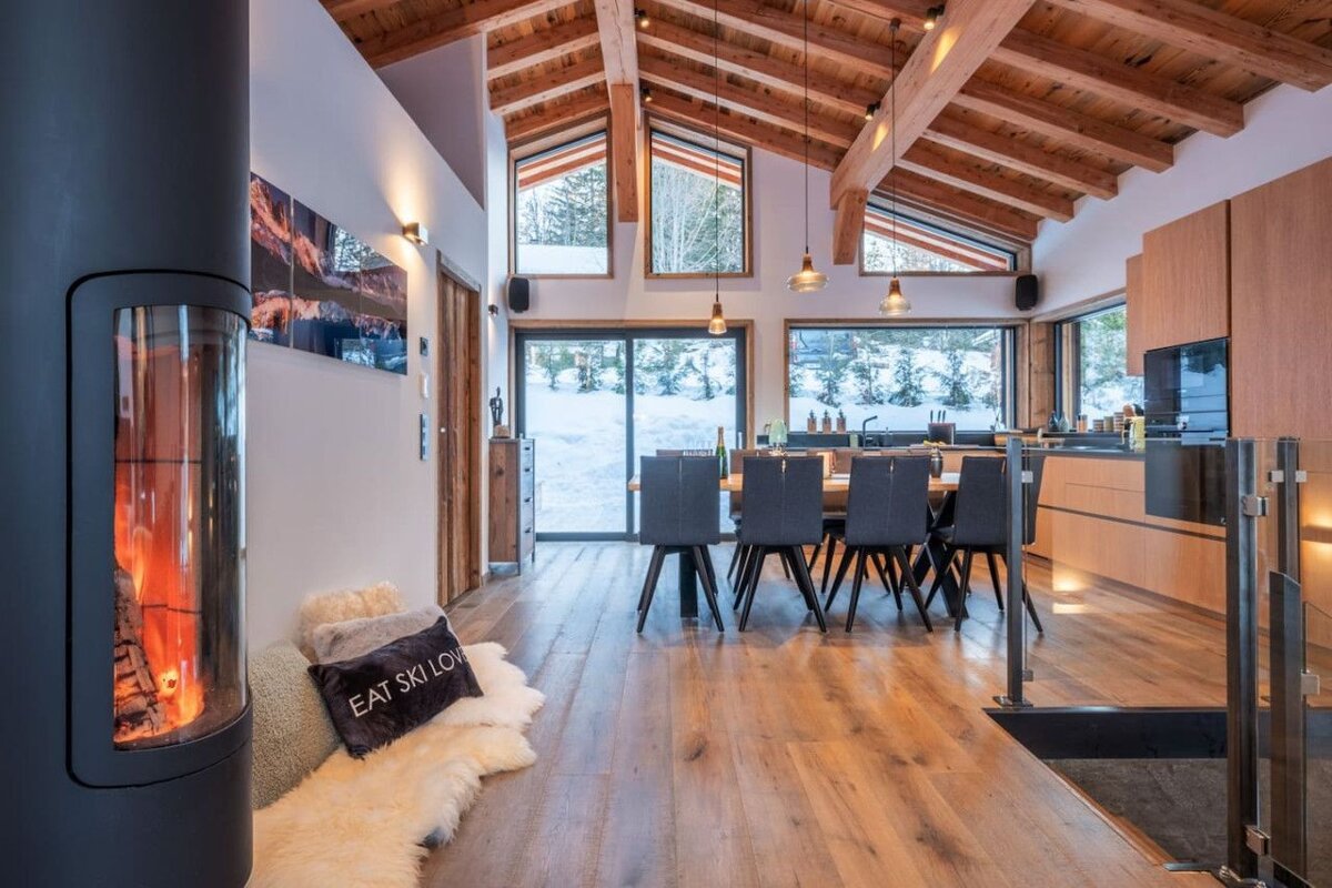 A pillow that says eat ski love sits next to a fireplace