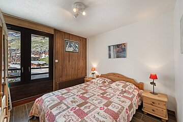 A bedroom with a bed a nightstand and a window