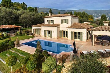 A large house with a large swimming pool in front of it