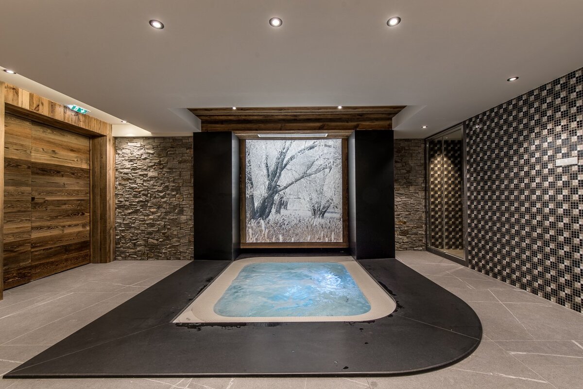 A jacuzzi in a room with a picture of trees on the wall