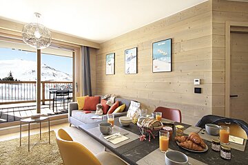 A living room with a couch and a dining table