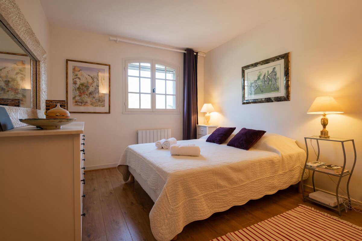 A bedroom with a large bed and two lamps
