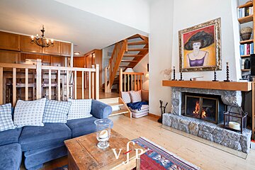 A living room with a fireplace and a painting of a woman on the wall