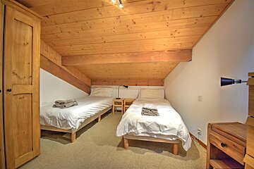 A bedroom with two twin beds and a nightstand