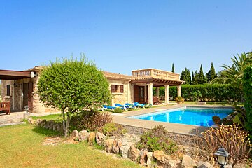 A house with a large swimming pool in front of it