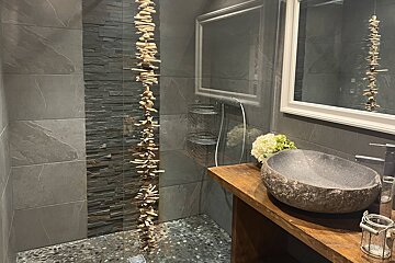 A bathroom with a stone sink and a mirror