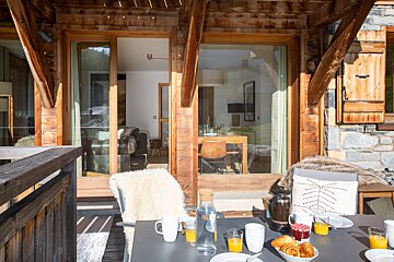 A table with a bowl of croissants and a pitcher of orange juice
