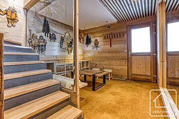 Stairs leading up to a room with a painting on the wall that says alpina