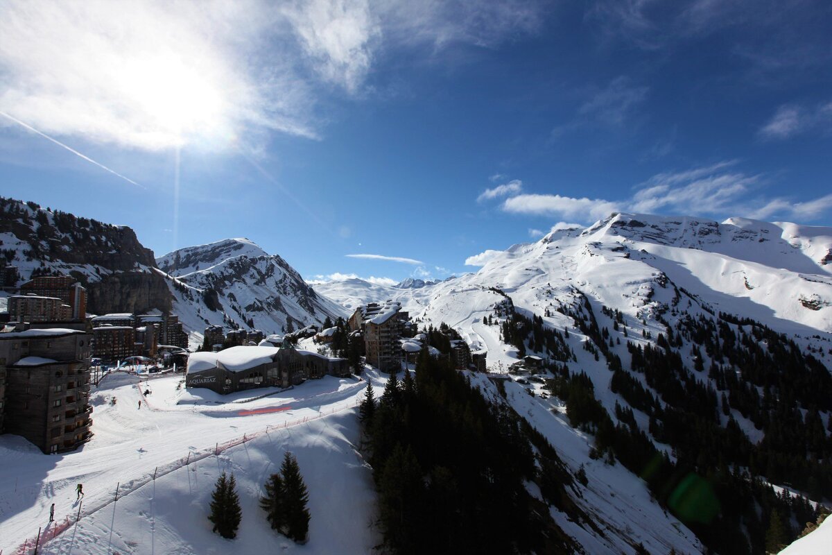 The sun is shining brightly over the snowy mountains