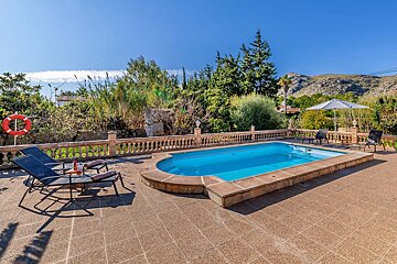A swimming pool surrounded by chairs and a life preserver