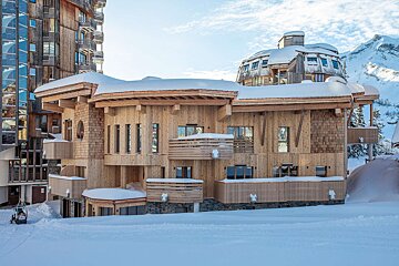 A large wooden building with snow on the roof