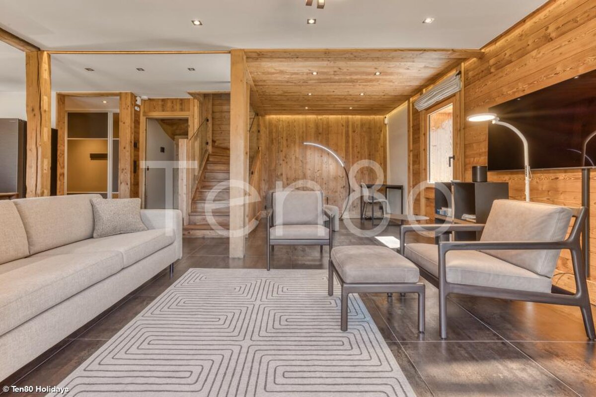 A living room with a couch and chairs and a sign that says ten80 holidays