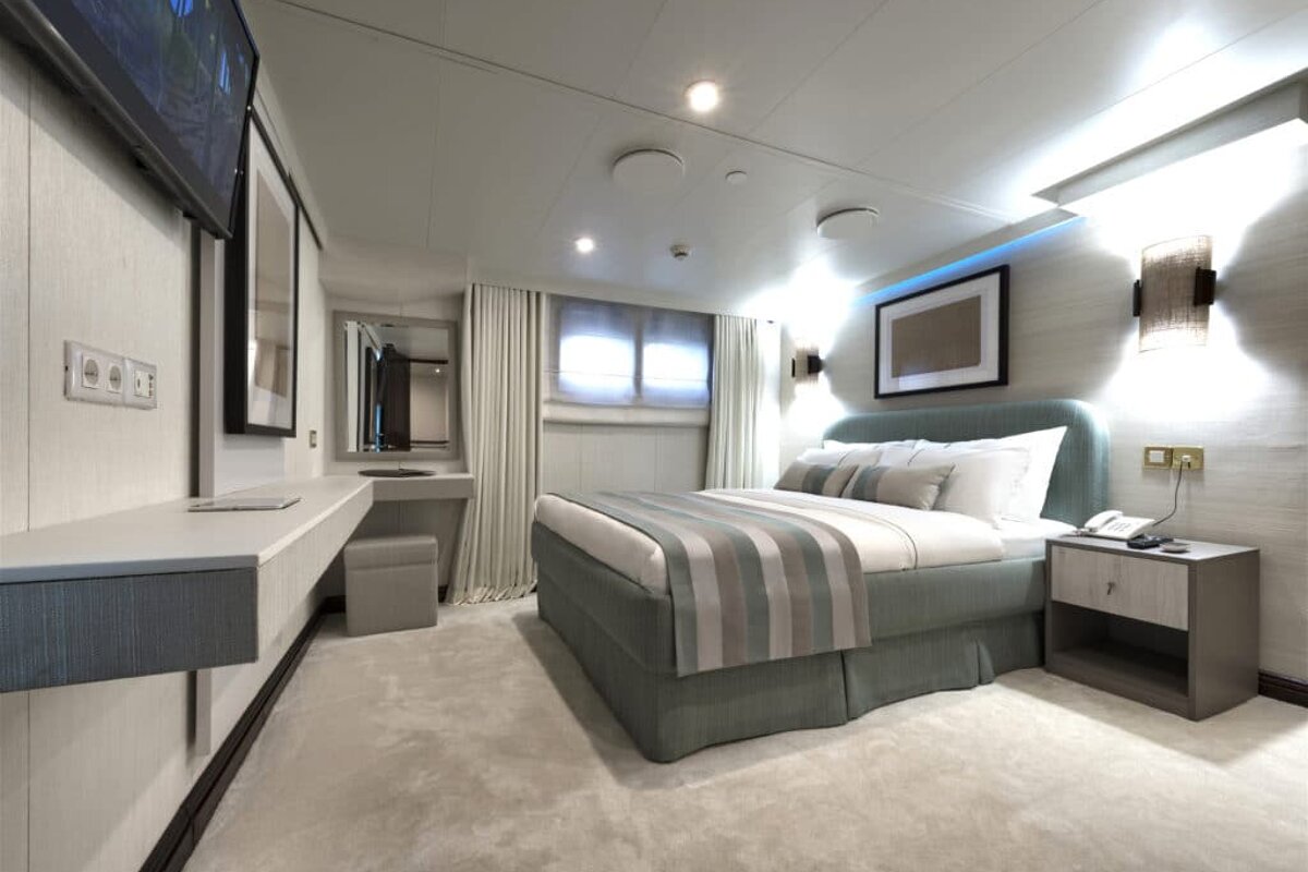 A bedroom with a bed and a television on the wall