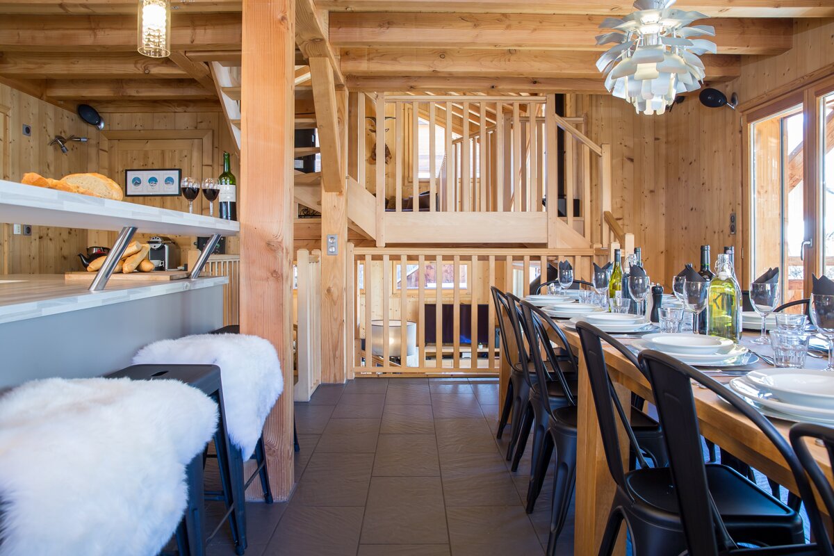 A dining room with a long table and chairs