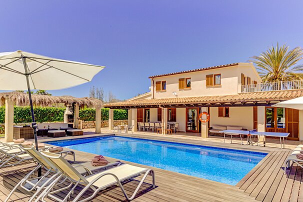 A house with a large swimming pool in front of it