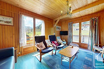 A living room with a table and chairs and a sign that says alpine-pro