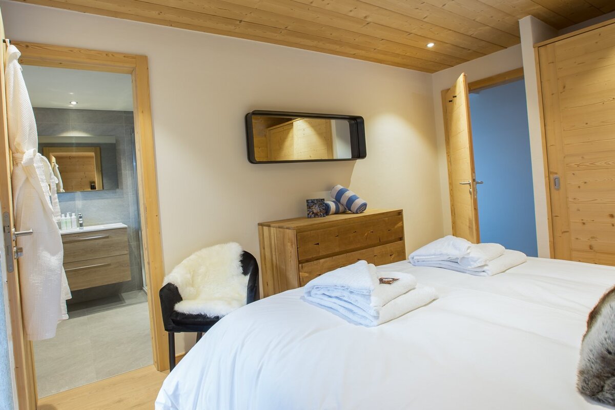 A bedroom with a large bed and a mirror above it