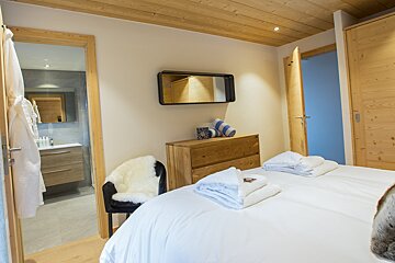 A bedroom with a large bed and a mirror above it