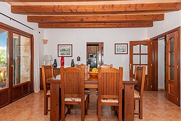 A dining room with a wooden table and chairs