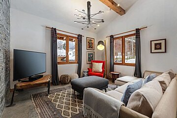A living room with a couch a chair and a flat screen tv