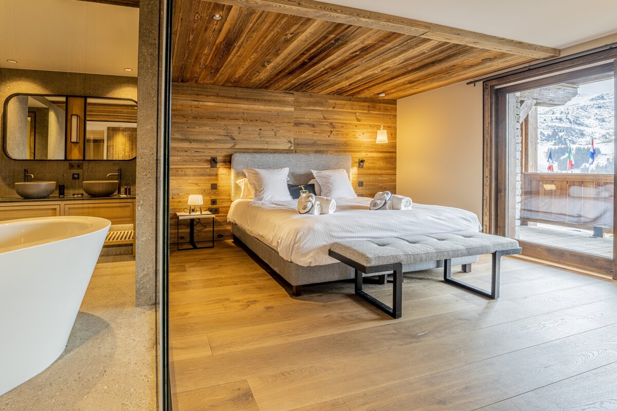 A bedroom with a large bed and a bathtub