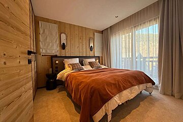 A bedroom with a large bed and a large window