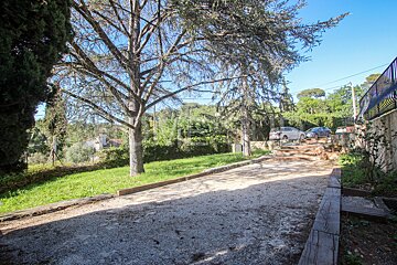 A gravel path leads to a lush green yard