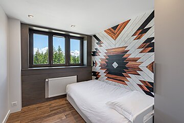 A bedroom with a single bed and a window