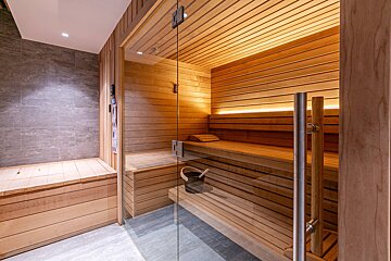 A wooden sauna with a glass door